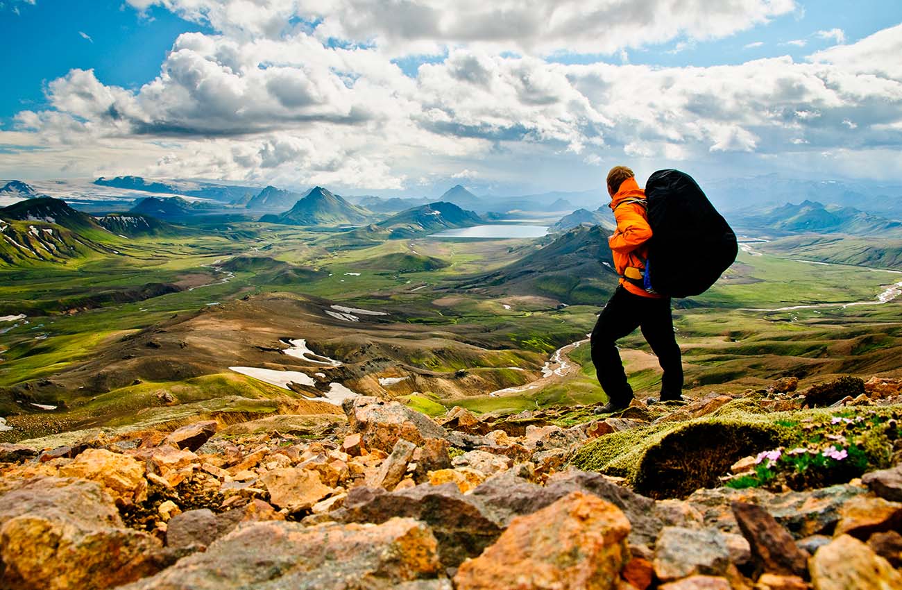 Billede af en mand på vantretur i Alftavatn, et flot bakket landskab på Island.