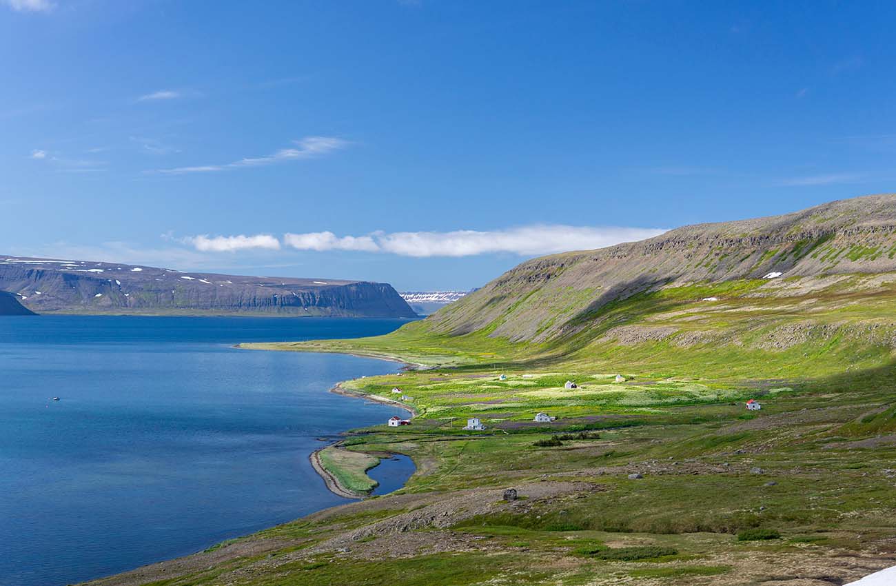Billede af en kyst med bjerge rundt omkring Hesteyri i Vestfjorden på Island.