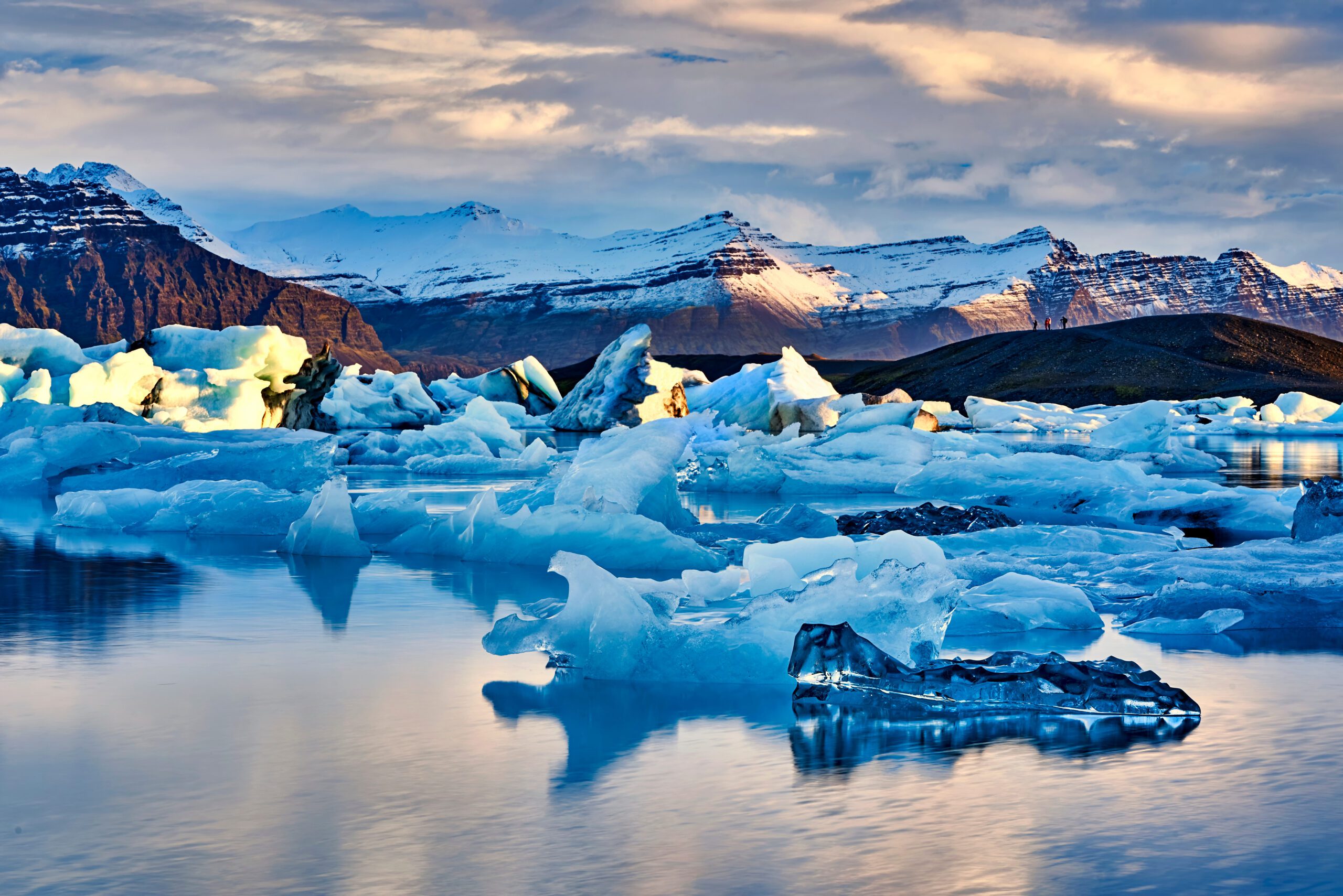 Billede af Jokulsarlon lagoon, en gletsjersø på Island, med flydende isbjerge og bjerge i baggrunden.
