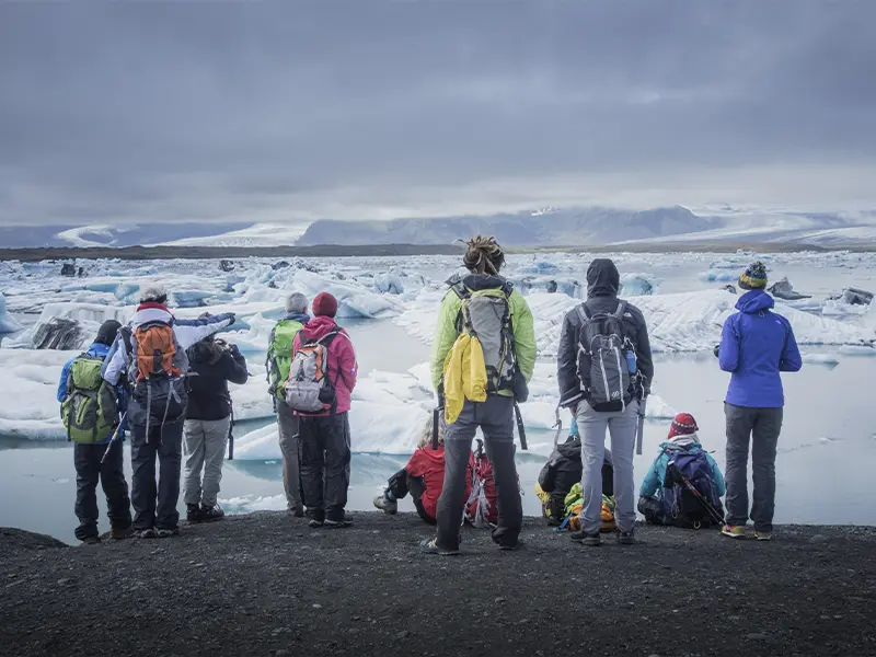 Personer står og kigger ud over Jökulsárlón