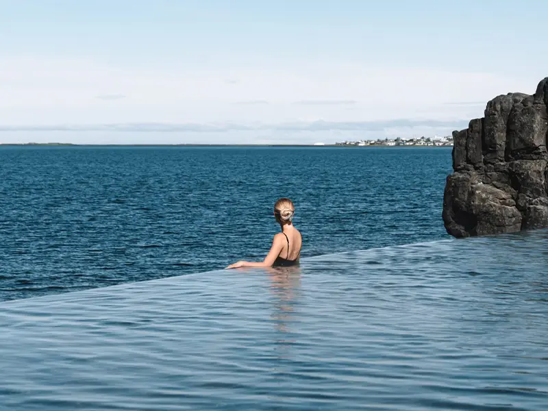 Kvinde nyder udsigten fra vandet i Sky Lagoon