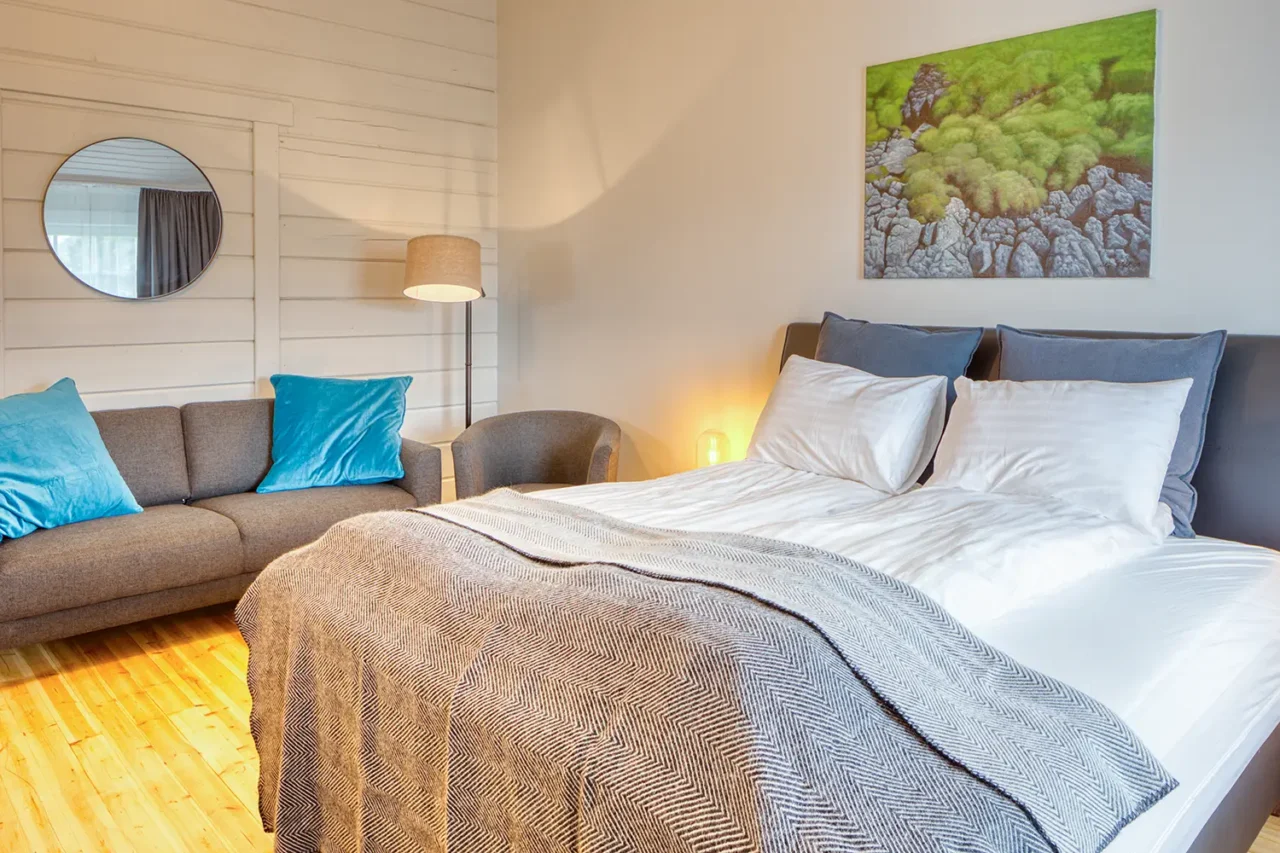 Dobbeltseng og sofa på i værelse på Hotel Breiddalsvik