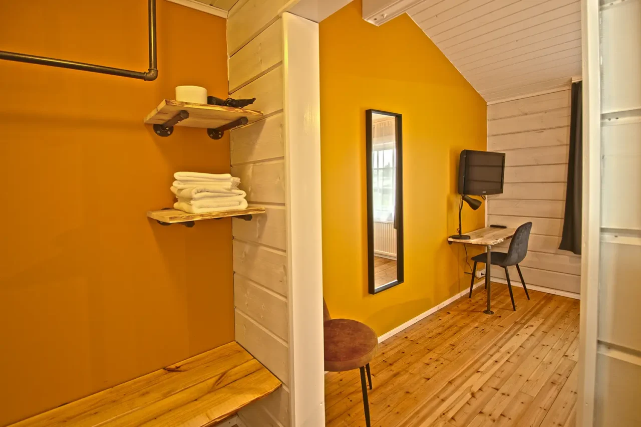 Komfortabelt værelse med skrivebord og TV på Hotel Breiddalsvik i Island