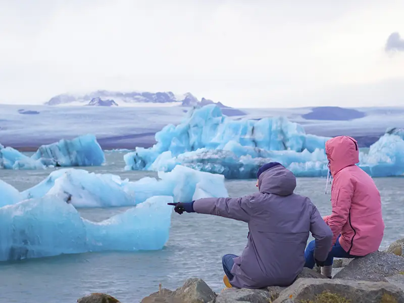 Turister beundrer isbjerge ved Jökulsárlón på Island