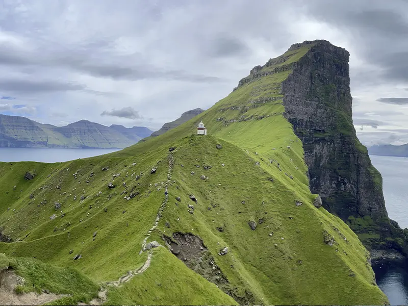 Bjergtop ved Kalsoy med sti og fyrtårn, Færøerne