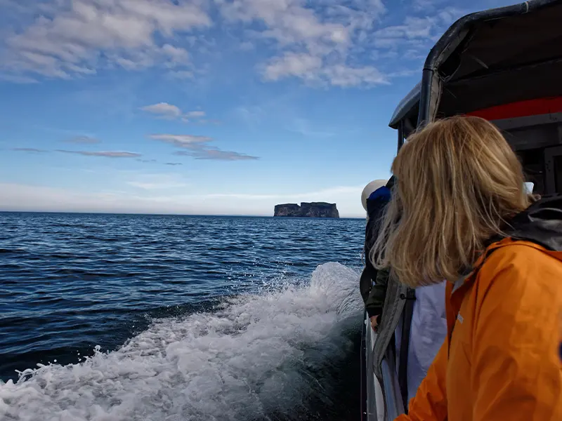 Personer sejler mod øen Drangey