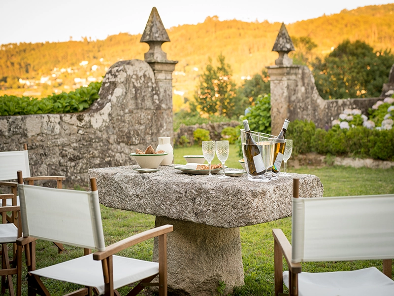 Et bord med en flaske vin og to glas på en vingård