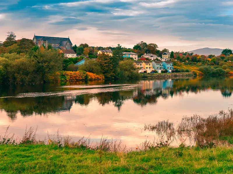 En sø og farverige huse i Irland